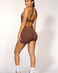 Person wearing a brown athletic outfit on a white background